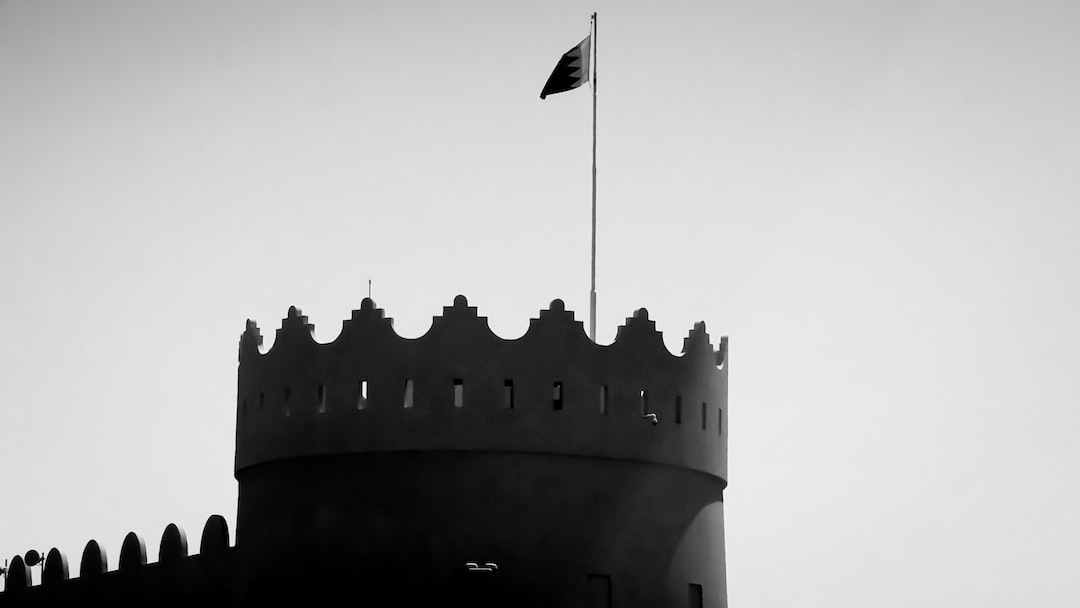a black and white photo of a tower with a flag on top